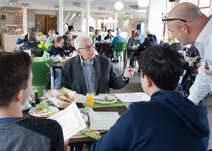 oudere man legt uit aan jongeren over zijn beroep 